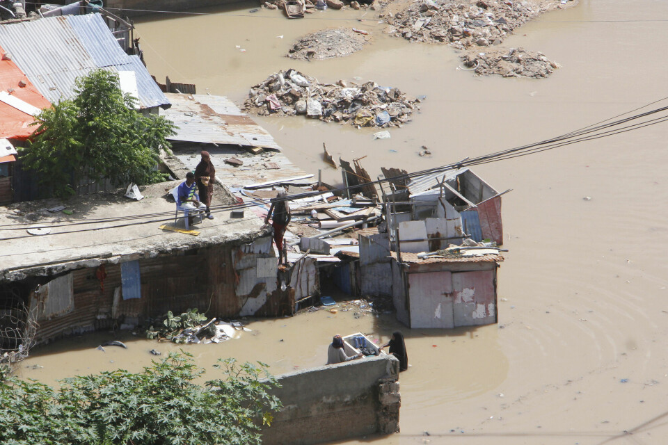 Noen personer har klatret opp på taket under flommen som følge av styrtregn i Mogadishu i Somalia. People stand on top of a flooded building following a heavy downpour, in Mogadishu, Somalia, Saturday, May 10, 2025. (AP Photo/Farah Abdi Warsameh)