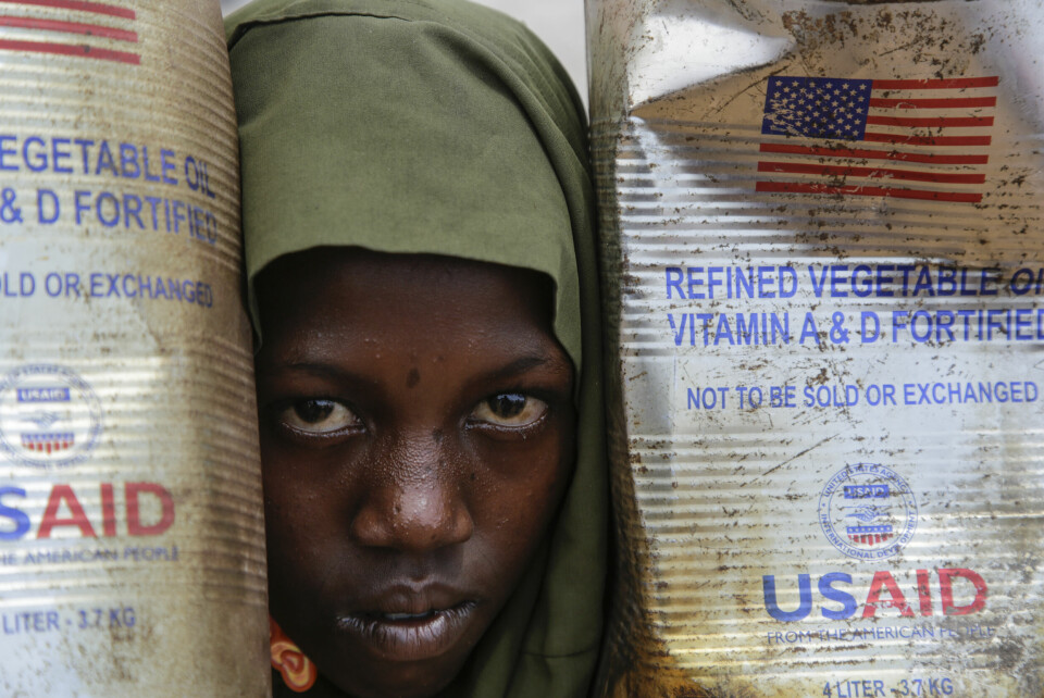 Et internt fordrevet barn kikker ut mellom kanner med matolje sendt av USAID til Maslah-leiren utenfor Mogadishu i Somalia i februar. Et internt fordrevet barn kikker ut mellom kanner med matolje sendt av USAID til Maslah-leiren utenfor Mogadishu i Somalia i februar. Foto: Farah Abdi Warsameh / AP / NTB