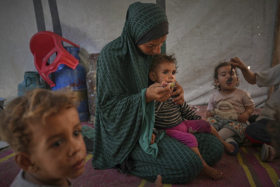 En palestinsk kvinne gir mat til barna sine i et telt i Gaza by lørdag. En palestinsk kvinne gir mat til barna sine i et telt i Gaza by lørdag. Foto: Jehad Alshrafi / AP / NTB