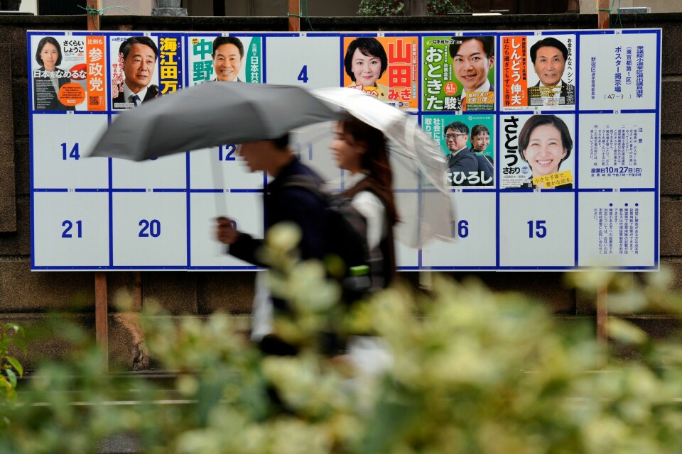 Valgplakater gatelangs i Tokyo før parlamentsvalget i oktober 2024.(Eugene Hoshiko/AP) Japanere på vei forbi valgplakater i Tokyo tidligere denne uken. Foto: Eugene Hoshiko / AP / NTB