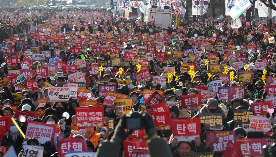 Folkemengden ropte på riksrett og at den sittende presidenten måtte gå av da de tok til gatene i Seoul, Sør-Korea.(Lee Jin-man/AP) Folk roper slagord mot president Yoon Suk-yeol utenfor nasjonalforsamlingen lørdag. Foto: Lee Jin-man / AP / NTB