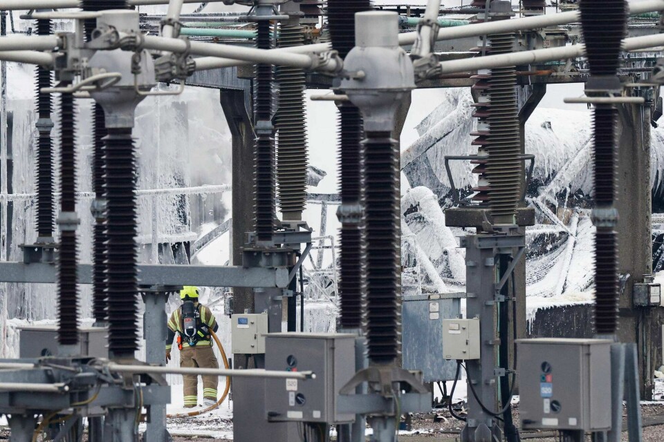 En brannkonstabel jobber med å slukke brannen i en tranformatorstasjon som forsyner en av verdens største flyplasser, Heathrow i London, med strøm. Brannen fører til at flyplassen er stengt.(BENJAMIN CREMEL/AFP) A firefighter douses flames of a fire that broke out at a substation supplying power to Heathrow Airport in Hayes, west London on March 21, 2025. Britain's Heathrow airport, Europe's busiest, was shut down early on March 21 for 24 hours after a major fire at an electricity substation cut power to the sprawling facility west of London, officials said. (Photo by BENJAMIN CREMEL / AFP)