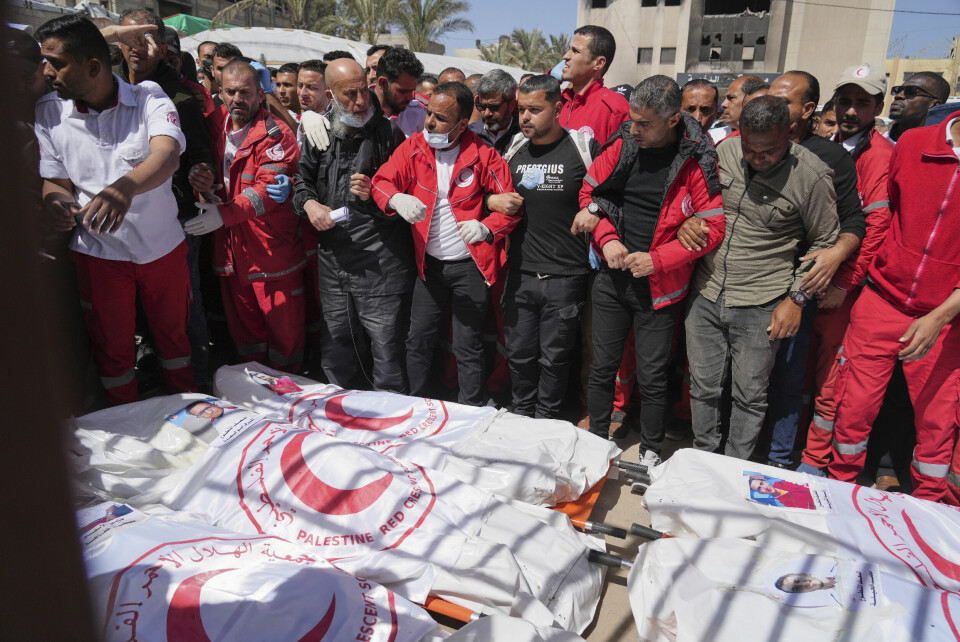 15 helsearbeidere, blant dem åtte fra Palestinsk Røde Halvmåne, ble drept da israelske soldater åpnet ild mot ambulanser i Rafah sør på Gazastripen 23. mars. Først en uke senere ble de drepte funnet i en massegrav. Sørgende kolleger og andre samler seg rundt bårene med åtte ambulansearbeidere fra Røde Halvmåne som ble drept av israelske soldater i Rafah for en drøy uke siden. Først i helgen fikk redningsmannskap lov å ta seg inn i området for å hente dem ut. De måtte grave dem ut fra en sandhaug. Foto: Abdel Kareem Hana / AP / NTB