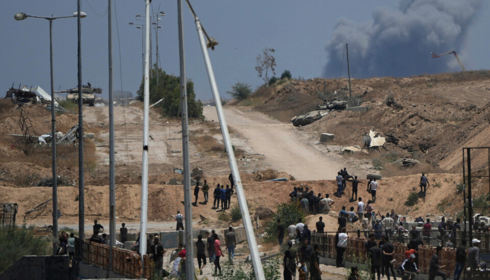 Israelske stridsvogner sett fra GHFs distribusjonssentral i Khan Younis sør på Gazastripen torsdag i forrige uke. Israeli army tanks are seen positioned as smoke rises in the background in southern Gaza, as seen from a humanitarian aid distribution center operated by the U.S.-backed Gaza Humanitarian Foundation, approved by Israel, in Khan Younis, southern Gaza Strip, on Thursday, May 29, 2025. (AP Photo/Abdel Kareem Hana)