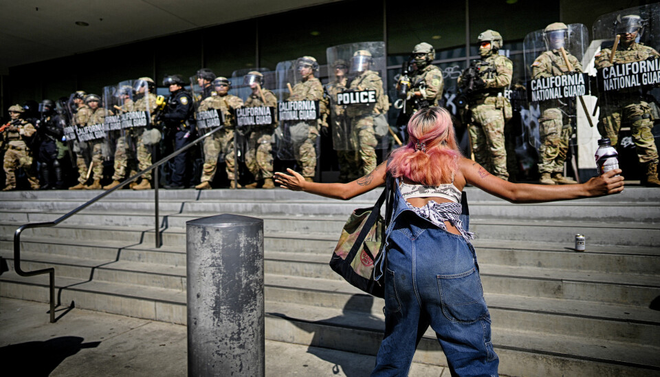 En demonstrant prøver å få nasjonalgardens oppmerksomhet utenfor en føderal bygning i Los Angeles.