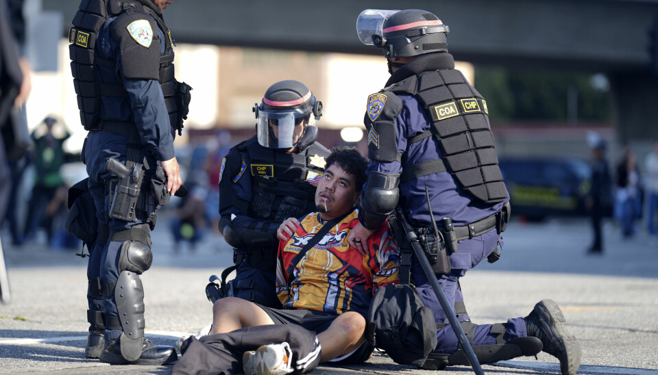 En demonstrant blir pågrepet av politi nær en føderal bygning i sentrum av Los Angeles tirsdag.