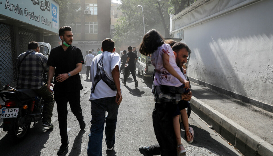 Folk løper etter israelske angrep på Teheran søndag. Folk løper etter israelske angrep på Teheran søndag.