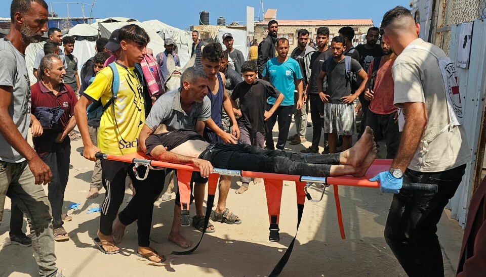 Palestinere bærer en såret mann, som ble skadet mens han sto i kø for nødhjelp, på vei til et sykehus i Rafah sør på Gazastripen mandag.