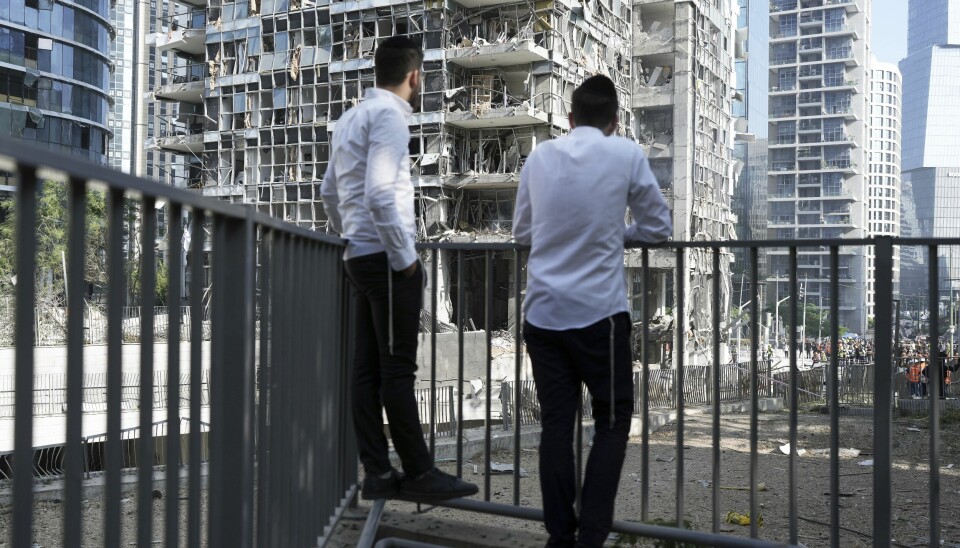 To menn observerer et bygg i Ramat Gan i Israel som ble truffet av en iransk rakett. Lenger sør i landet er et sykehus rammet i et rakettangrep.