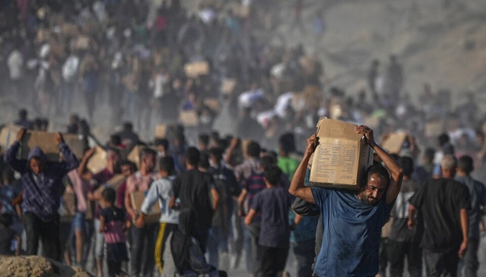 Israel slipper inn minimale mengder med mat og annen nødhjelp i Gaza, og sulten øker, advarer FNs nødhjelpskontor. Bildet viser palestinere som bærer på matkasser de har fått fra FNs matvareprograms 16. juni.