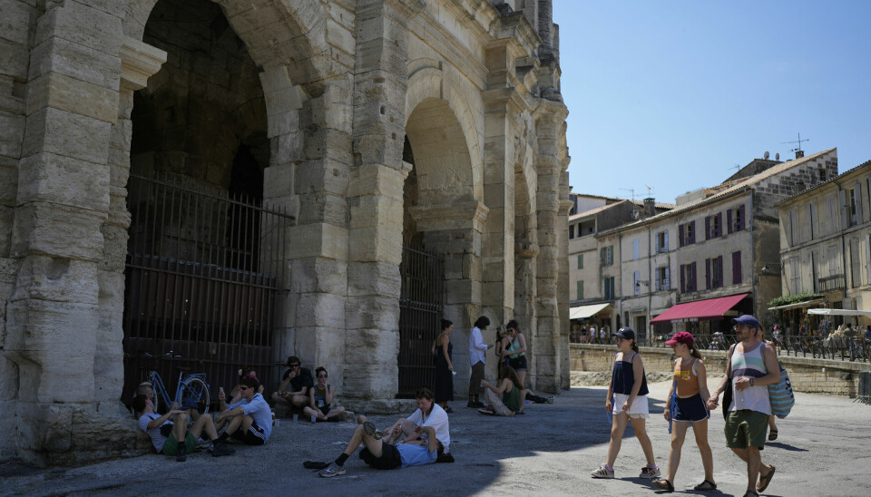 Folk søker tilflukt fra varmen i skyggen i Arles, sør i Frankrike.